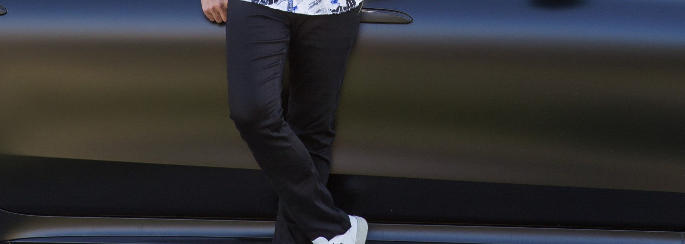 Un jeans propre de la marque Au noir de couleur noir devant une voiture de luxe