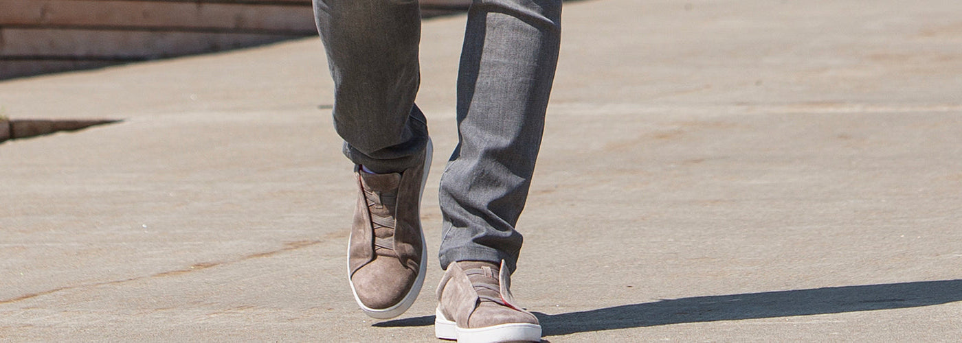 Souliers homme gris avec jeans ajustés, style urbain chic.