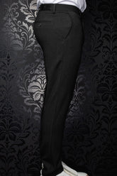 Pantalon noir vu de côté, avec passants, poche arrière passepoilée et texture tissée subtile pour homme par Au Noir