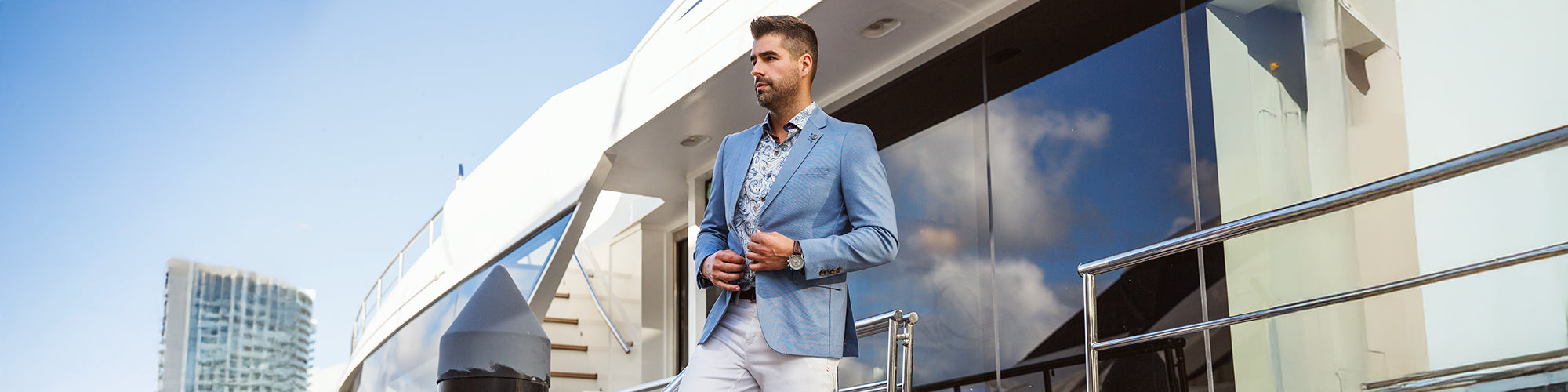 un homme habillé à la mode fashion portant un veston bleu et une chemise blanche à pois 