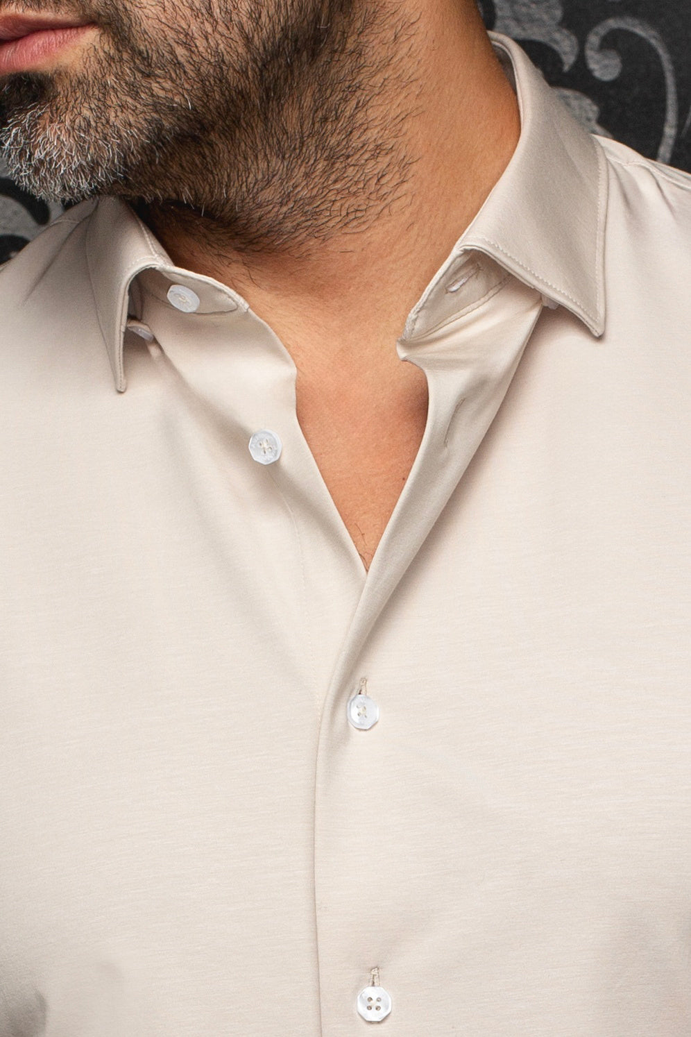 Col de chemise beige pâle et patte ouverte à boutons blancs pour homme par Au Noir, en gros plan