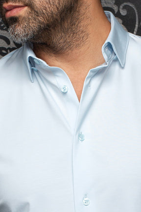 Gros plan sur le col de la chemise bleue pâle, la patte ouverte et les boutons ton sur ton pour homme par Au Noir