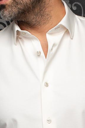 Gros plan du col d'une chemise blanche avec boutons nacrés et tissu lisse pour homme par Au Noir