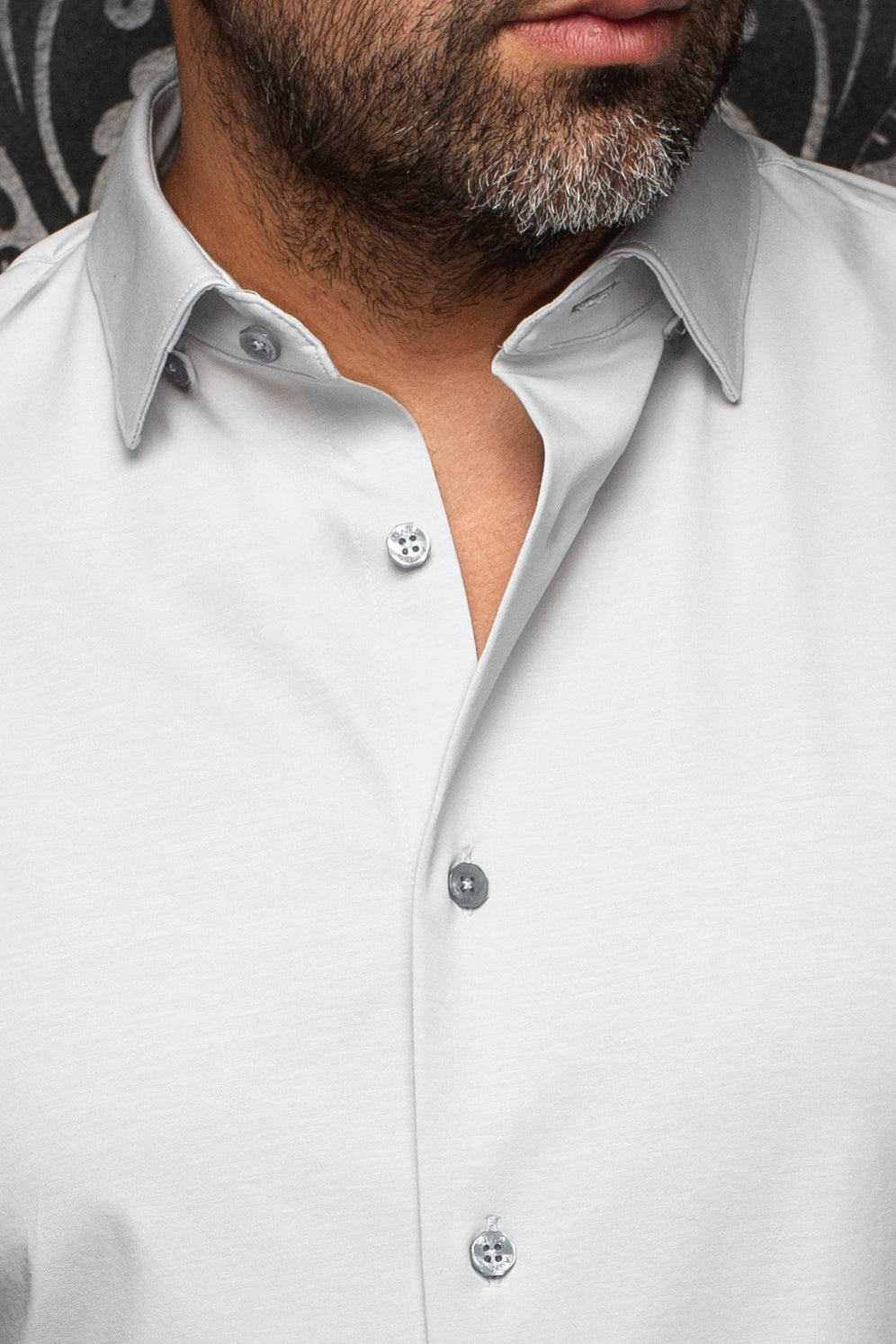 Chemise gris pâle avec col et patte de boutonnage, boutons gris et texture subtile pour homme par Au Noir, en gros plan