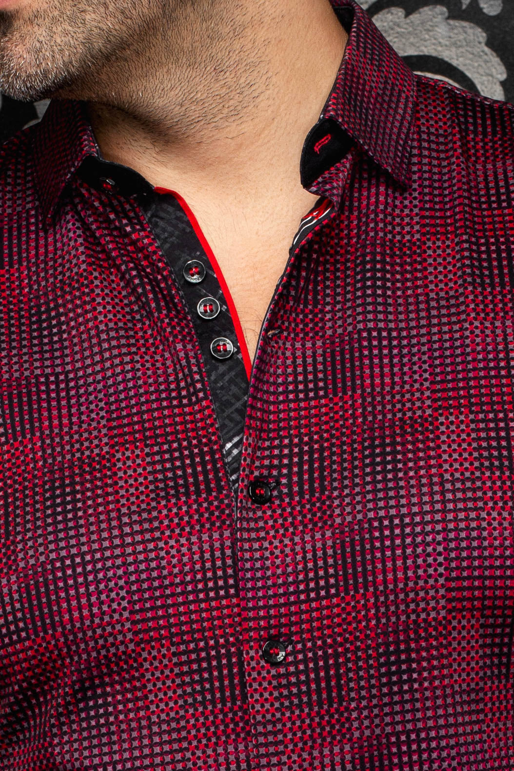 Gros plan du col de chemise rouge et noir à micro-carreaux, patte noire, boutons et passepoil rouge pour homme par Au Noir