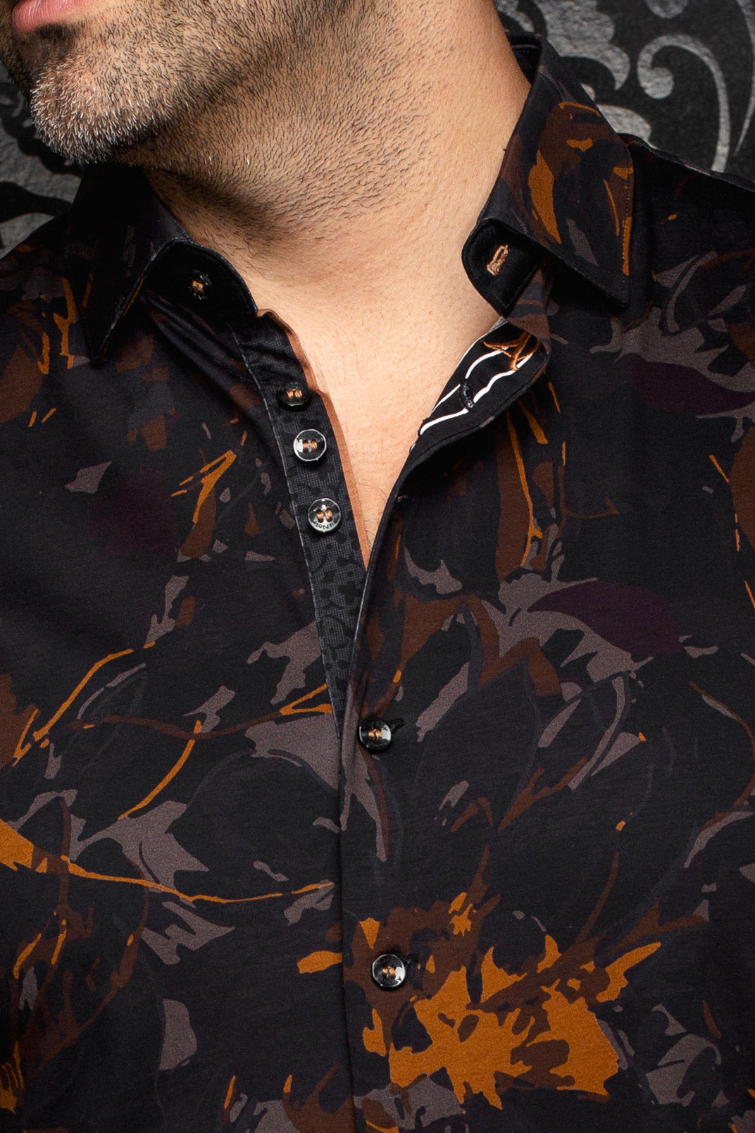 Col, de la patte boutonnée et motif brun rouille d'une chemise noire pour homme par Au Noir, en gros plan
