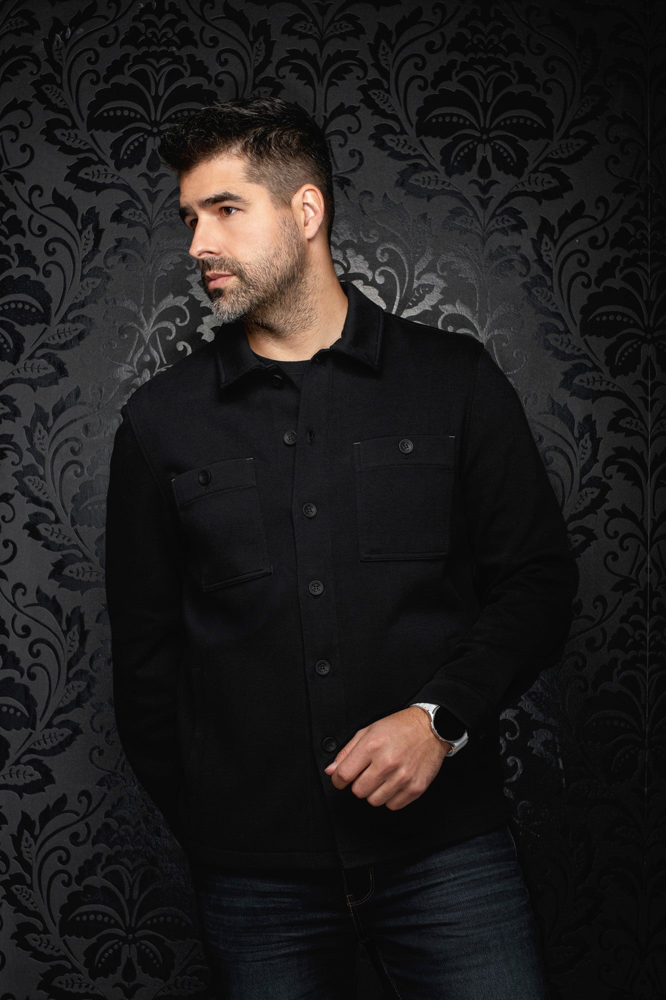 Surchemise noire sur mannequin, vue avant en angle avec boutons ton sur ton et poches pour homme par Au Noir