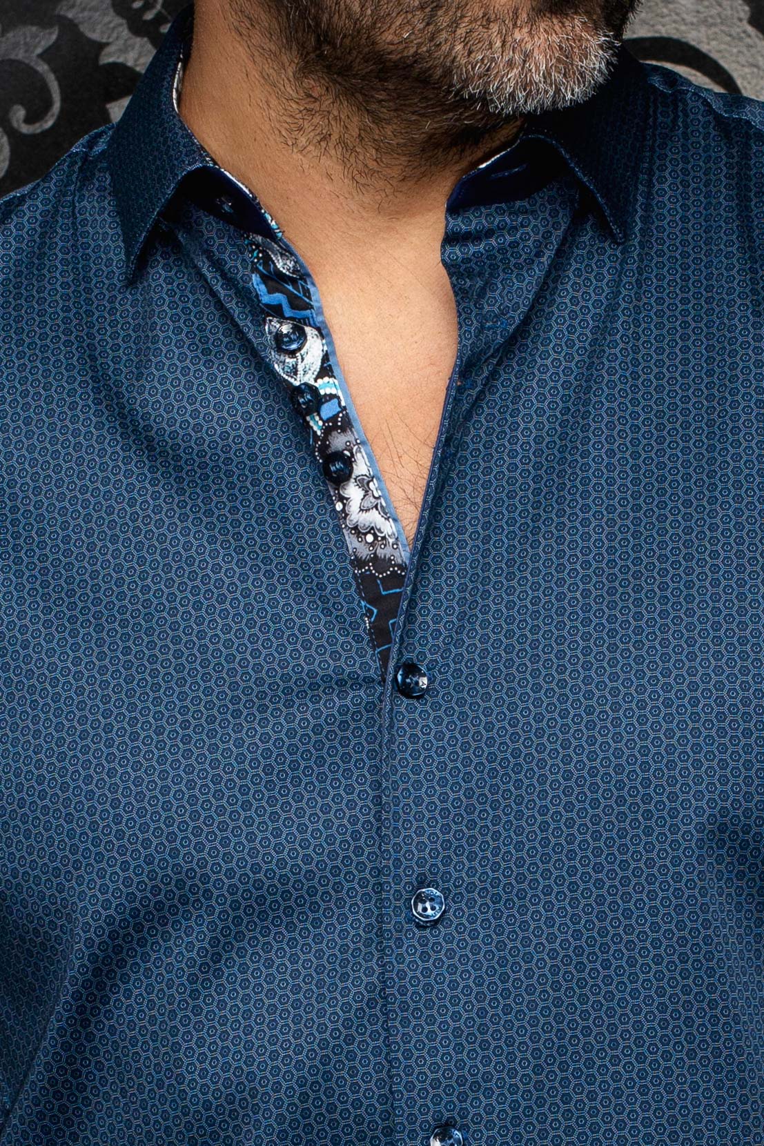 Gros plan sur la chemise boutonnée bleue à motif avec col ouvert et patte intérieure florale pour homme par Au Noir