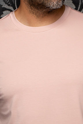 Gros plan d’un T-Shirt rose pâle à col rond côtelé et surface en tricot lisse pour homme par Au Noir