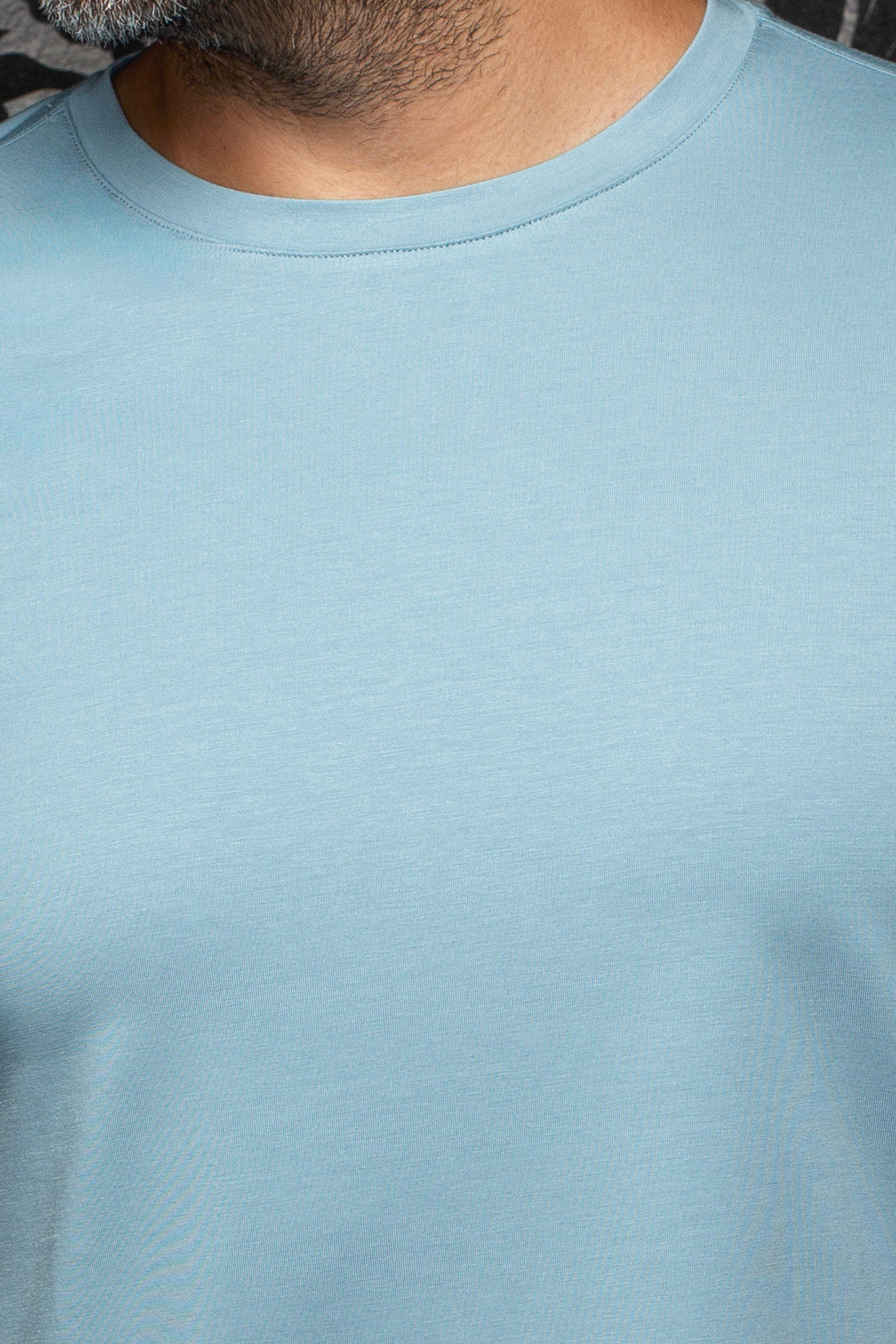T-Shirt bleu pâle montrant le col rond côtelé et la texture jersey lisse pour homme par Au Noir, en gros plan