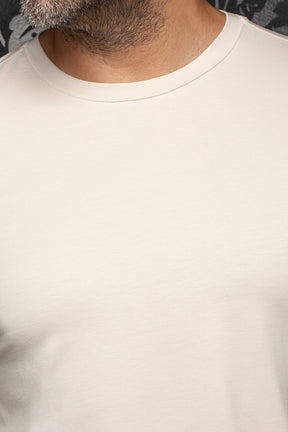 Col rond du T-Shirt crème, tissu tricot lisse et coutures ton sur ton pour homme par Au Noir, en gros plan