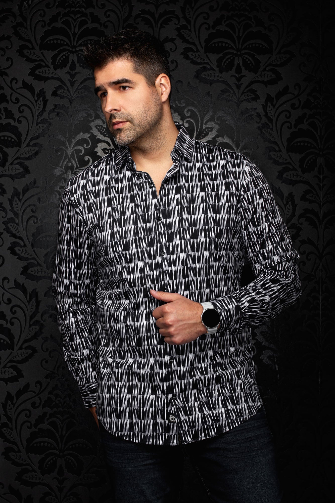 Vue en angle d’une chemise noire et blanche à motif abstrait, col ouvert et manches longues pour homme par Au Noir