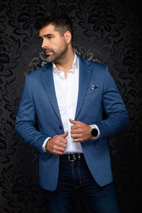 Vue de face en angle d’un veston bleu texturé avec revers crantés, épinglette et pochette pour homme par Au Noir