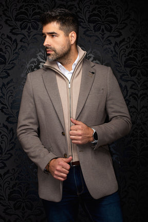 Vue avant en angle d’un veston taupe texturé à revers crantés, boutons bruns et épinglette pour homme par Au Noir