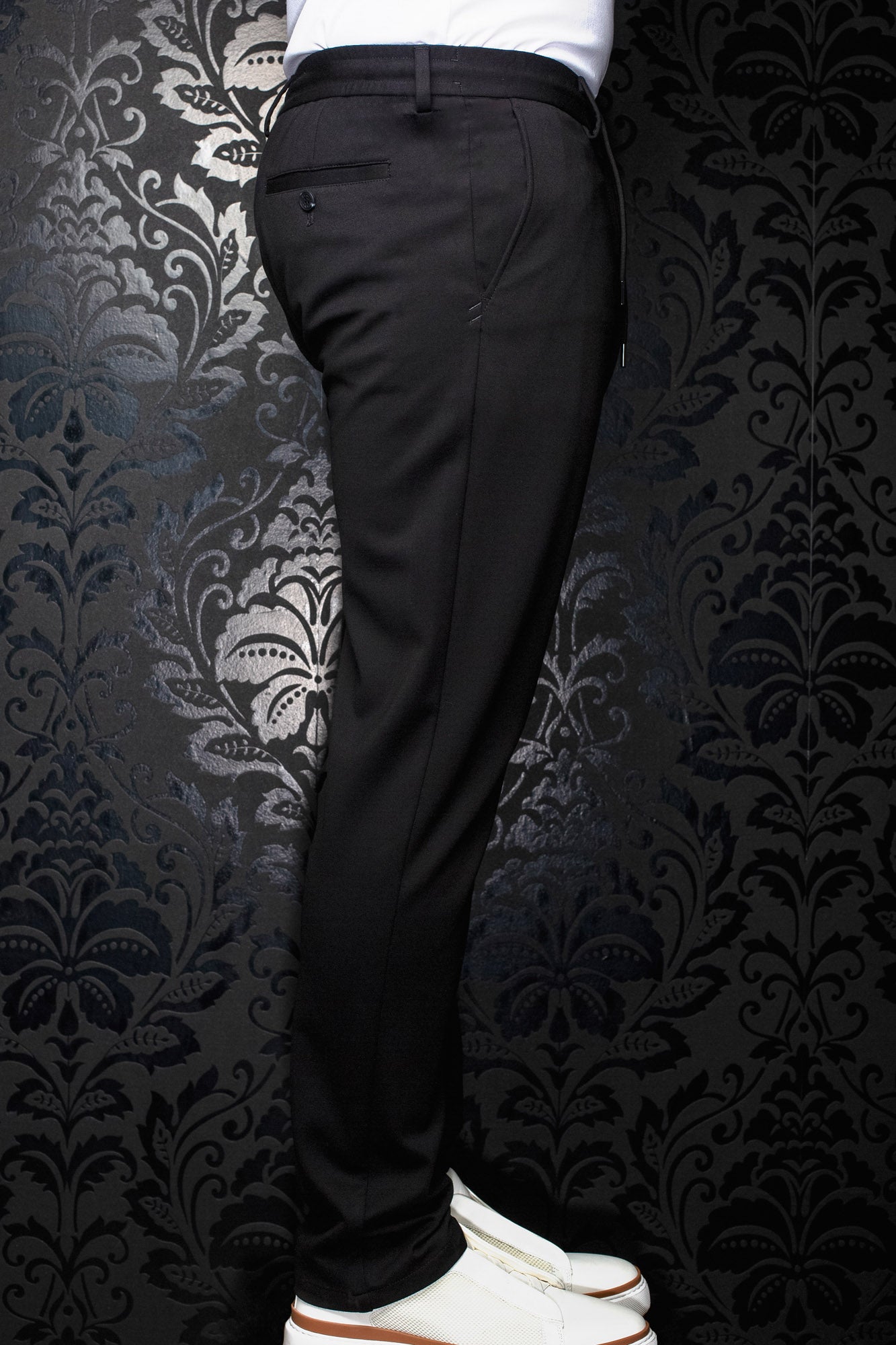 Pantalon noir vu de côté, avec passants, poche arrière passepoilée boutonnée et jambe fuselée pour homme par Au Noir