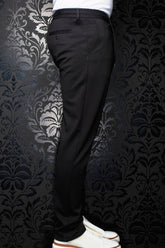 Pantalon noir vu de côté, avec passants, poche arrière passepoilée boutonnée et jambe fuselée pour homme par Au Noir