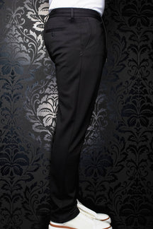 Pantalon noir vu de côté, avec passants, poche arrière passepoilée boutonnée et jambe fuselée pour homme par Au Noir