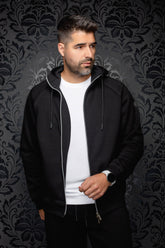 Veste sport noire à capuchon ouverte, glissière argentée et cordons pour homme par Au Noir, vue de face sur mannequin