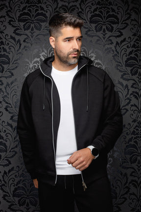 Veste sport noire à capuchon ouverte, glissière argentée et cordons pour homme par Au Noir, vue de face sur mannequin
