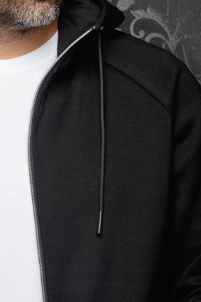 Veste sport noire à capuchon avec glissière argentée, cordon et panneau texturé pour homme par Au Noir, en gros plan