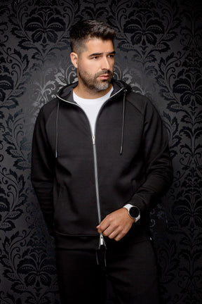 Veste sport noire à capuchon, glissière argentée et poches pour homme par Au Noir, vue de face sur mannequin