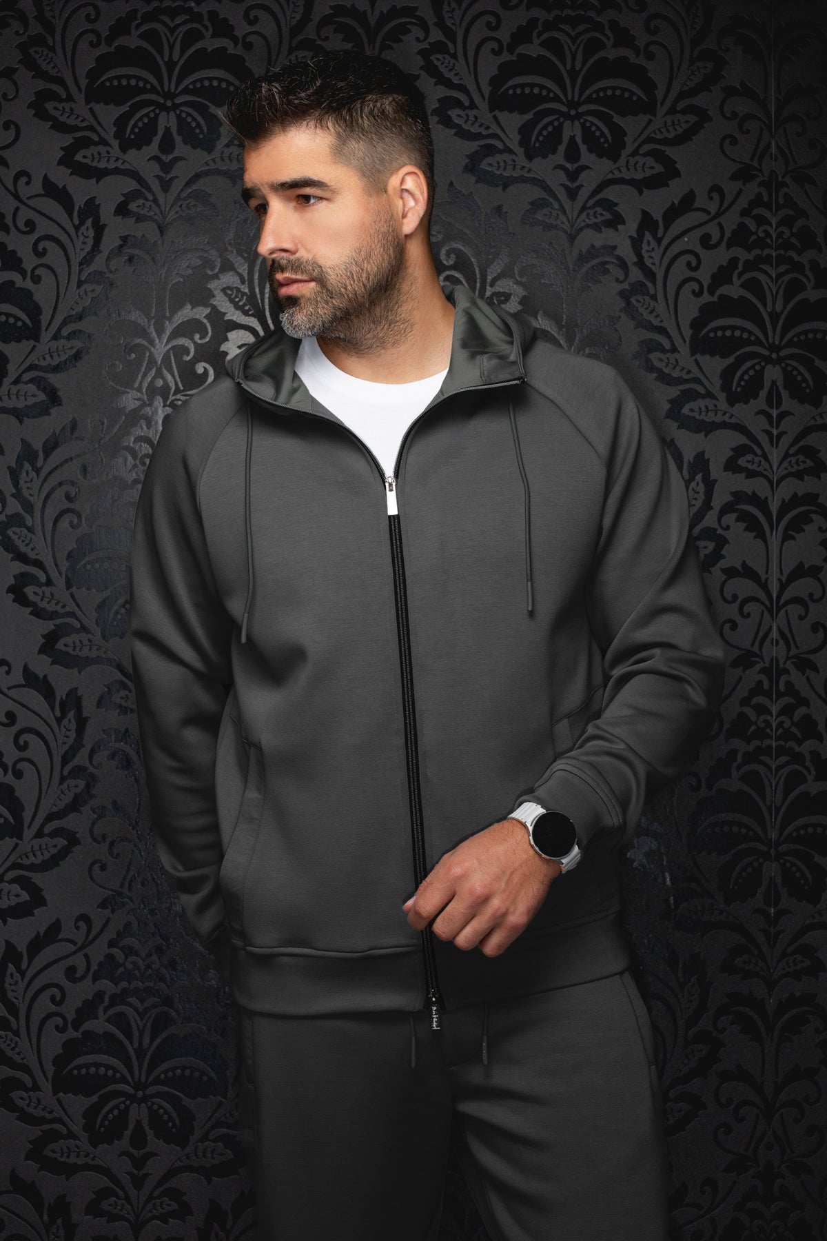 Veste sport à capuchon gris foncé sur mannequin, vue de face avec fermeture noire et cordons pour homme par Au Noir