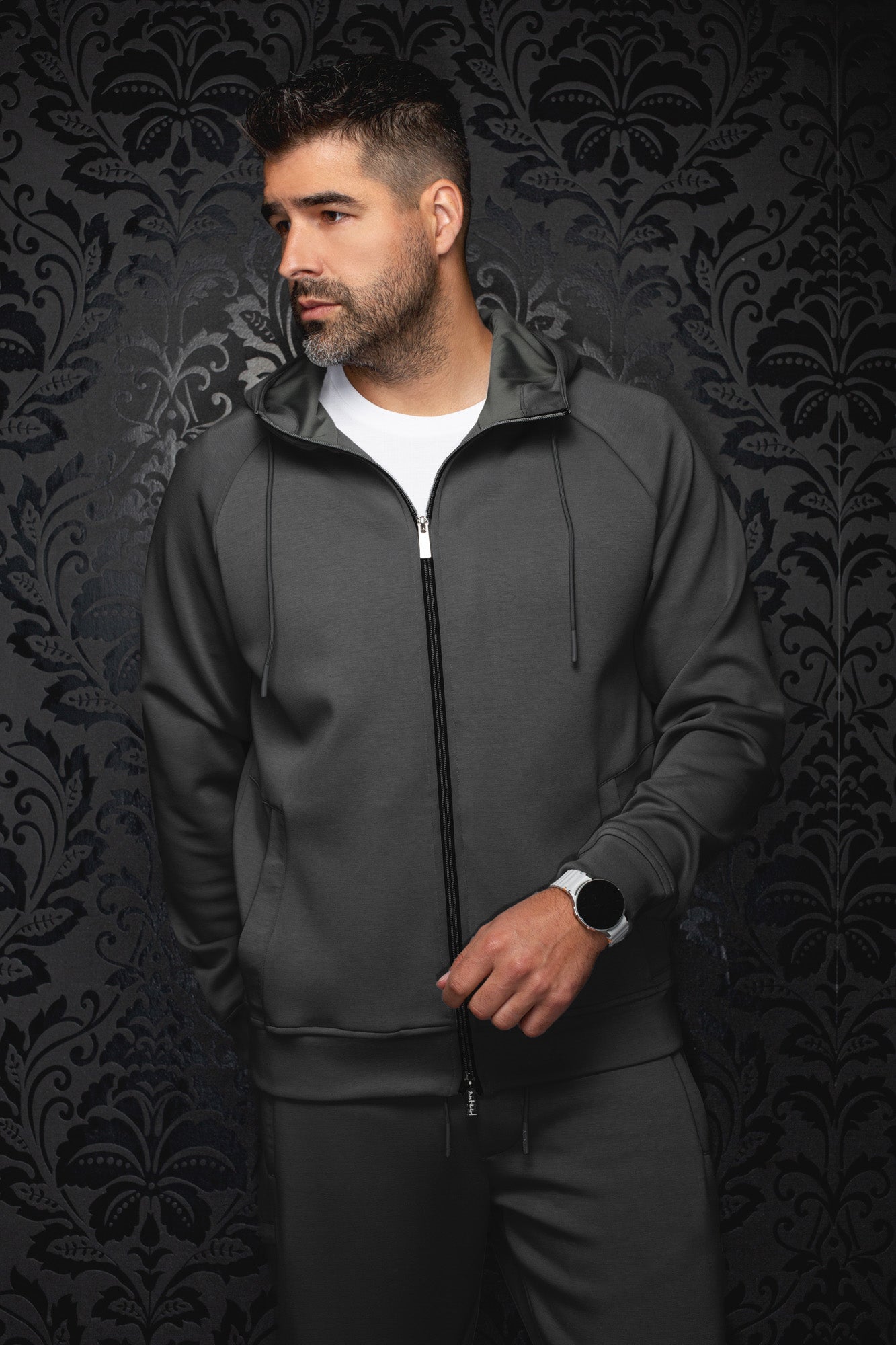 Veste sport à capuchon gris foncé sur mannequin, vue de face avec fermeture noire et cordons pour homme par Au Noir