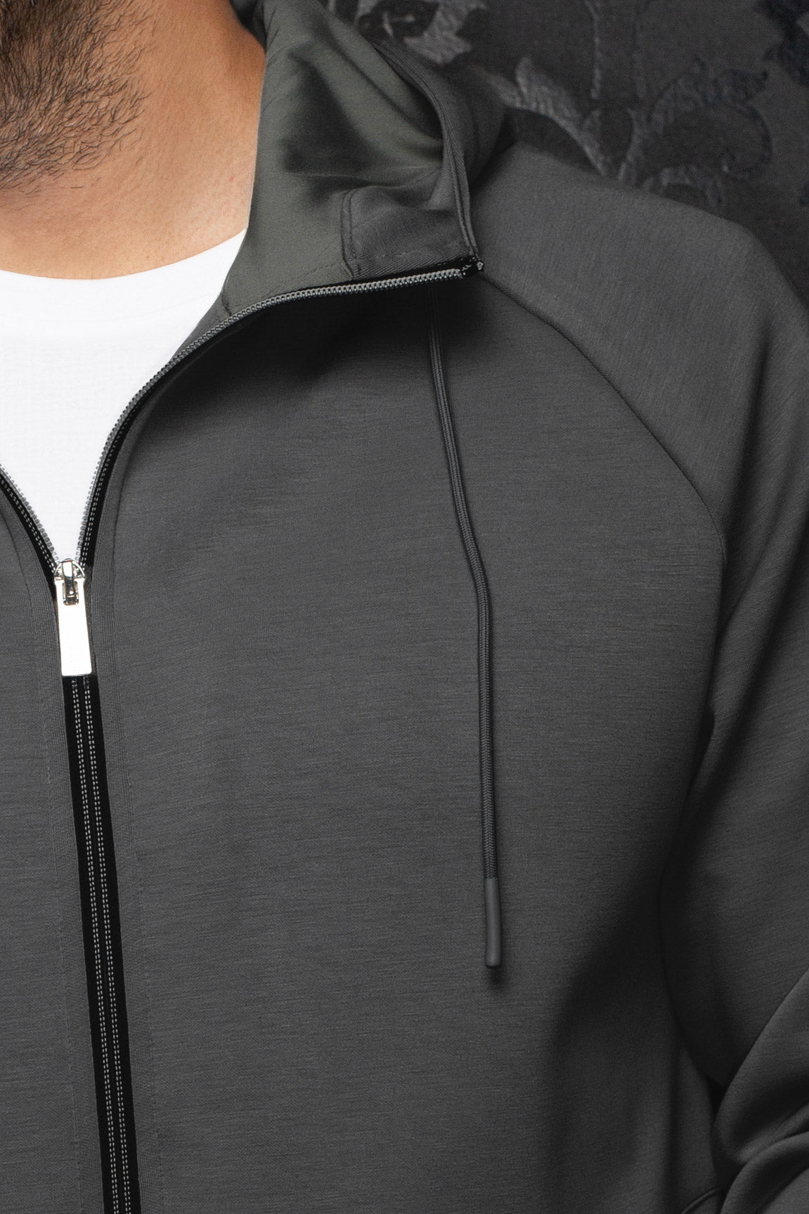 Veste sport à capuchon gris foncé avec fermeture noire, cordon et texture pour homme par Au Noir, en gros plan