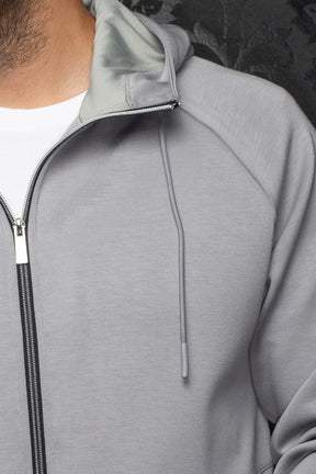 Veste sport à capuchon gris pâle avec doublure, glissière noire et cordon pour homme par Au Noir, en gros plan
