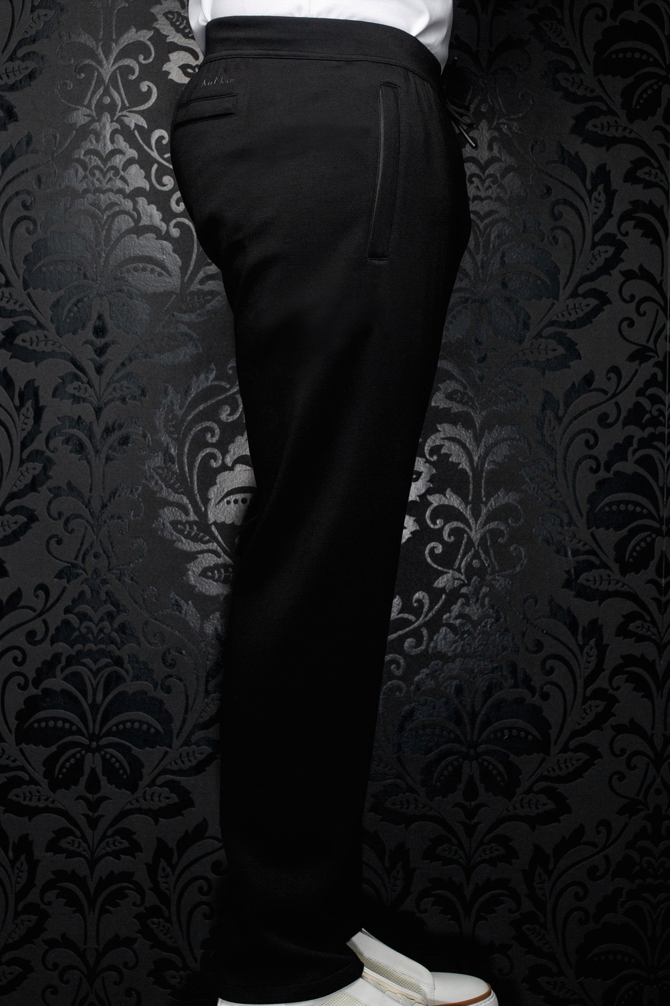 Vue de côté du pantalon jogging noir avec taille élastique, cordon et poche verticale pour homme par Au Noir
