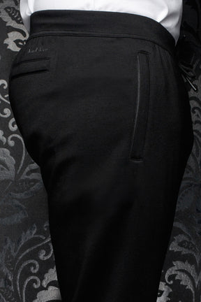 Pantalon jogging noir avec taille large, poche passepoilée et logo ton sur ton pour homme par Au Noir, en gros plan