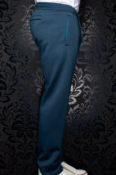 Men's side-back view of teal jogging pants with drawcord waistband and vertical zip pocket by Au Noir