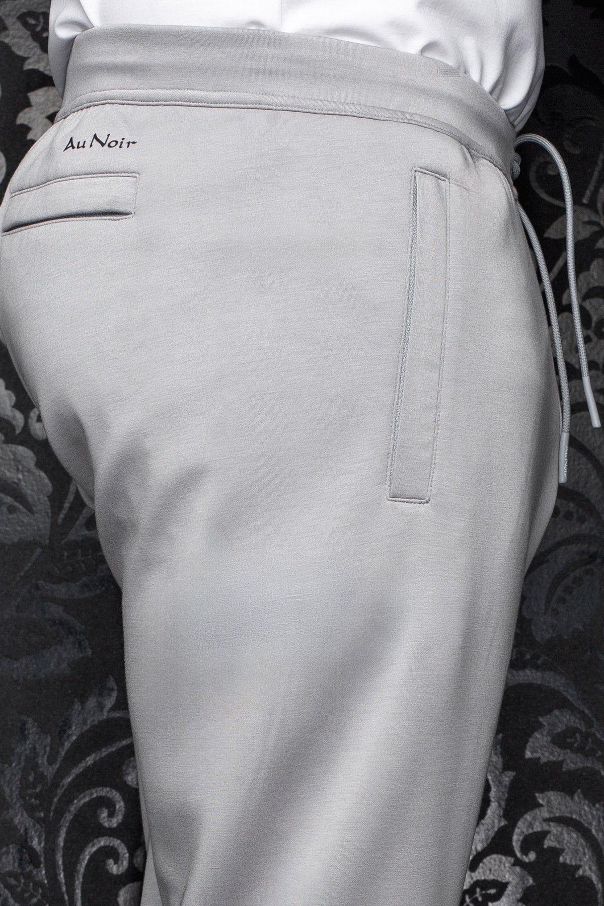 Pantalon jogging gris pâle avec taille à cordon, poches passepoilées et logo Au Noir noir pour homme, en gros plan