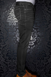 Jean noir vu de côté, avec surpiqûres contrastantes, poche arrière et écusson à la taille pour homme par Au Noir