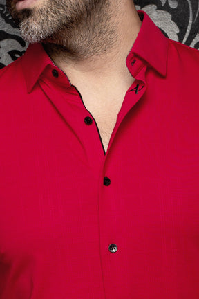 Au Noir men's red button-up shirt collar with black buttons, black trim, and small A embroidery, close-up