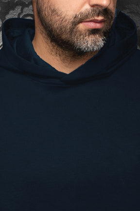 Veste sport à capuchon bleu marine montrant l’encolure et le devant uni pour homme par Au Noir, en gros plan