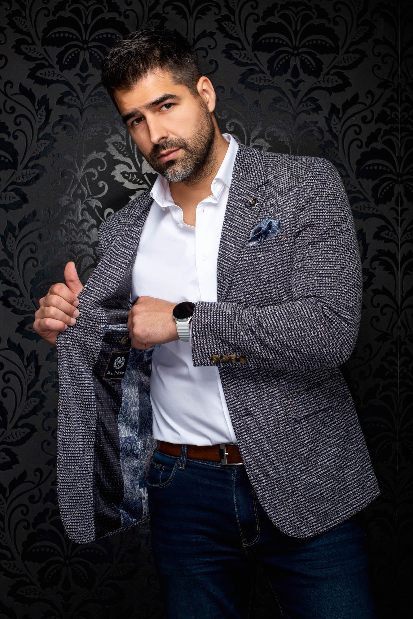 Au Noir men's angled view of a navy textured blazer opened to show blue patterned lining and interior label, side view