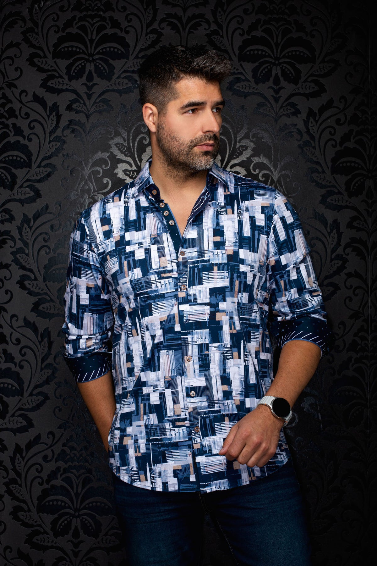 Au Noir men's navy geometric-print button-up shirt on model, with rolled cuffs and contrast cuff facing visible, side view