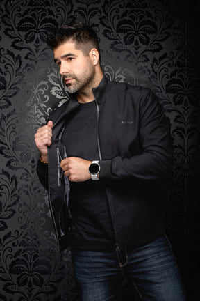 Vue en angle d’un coupe-vent mi-saison style bomber bomber noire ouverte avec doublure foncée pour homme par Au Noir