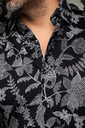 Col et patte d’une chemise noire à motif floral blanc et boutons noirs pour homme par Au Noir, en gros plan