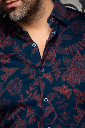 Gros plan d’une chemise bleu marine à fleurs, avec col classique, boutons bleus et motif bourgogne pour homme par Au Noir