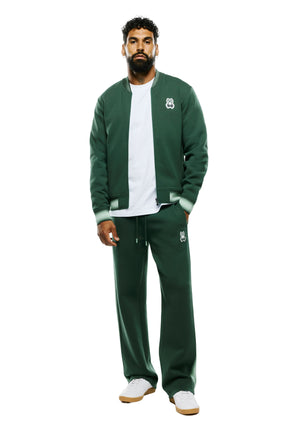 Vue de face plein pied du pantalon jogging sport vert foncé à cordon et écusson logo à la cuisse pour homme par Psycho Bunny