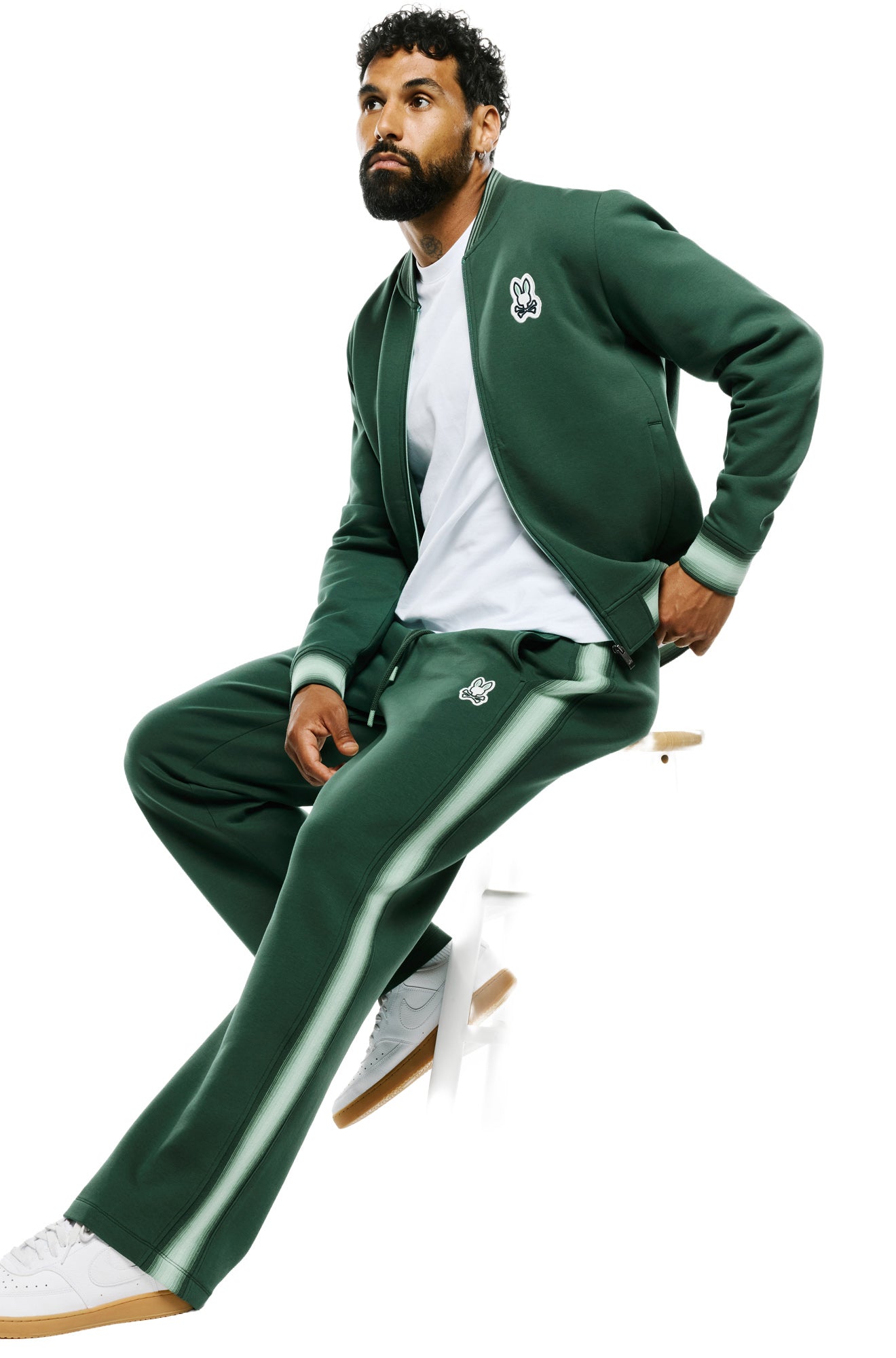 Vue assise en angle du pantalon jogging sport vert foncé avec bande latérale vert pâle pour homme par Psycho Bunny