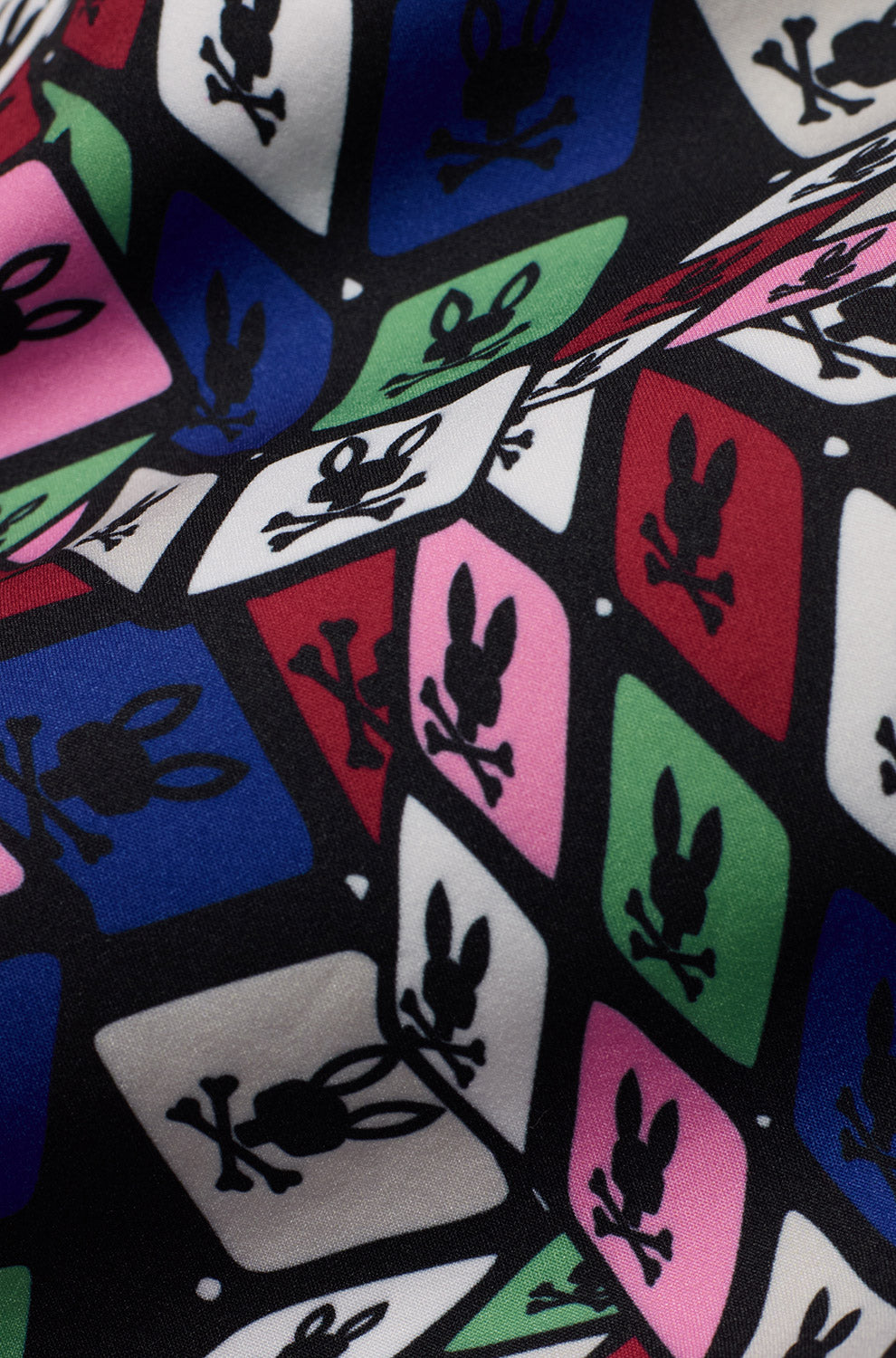 Gros plan du short maillot noir lisse avec motif géométrique multicolore Psycho Bunny sur tissu pour homme