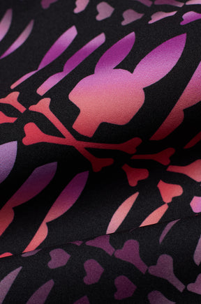 Gros plan du short maillot noir à imprimé graphique lapin tête de mort rose et mauve avec tissu pour homme par Psycho Bunny
