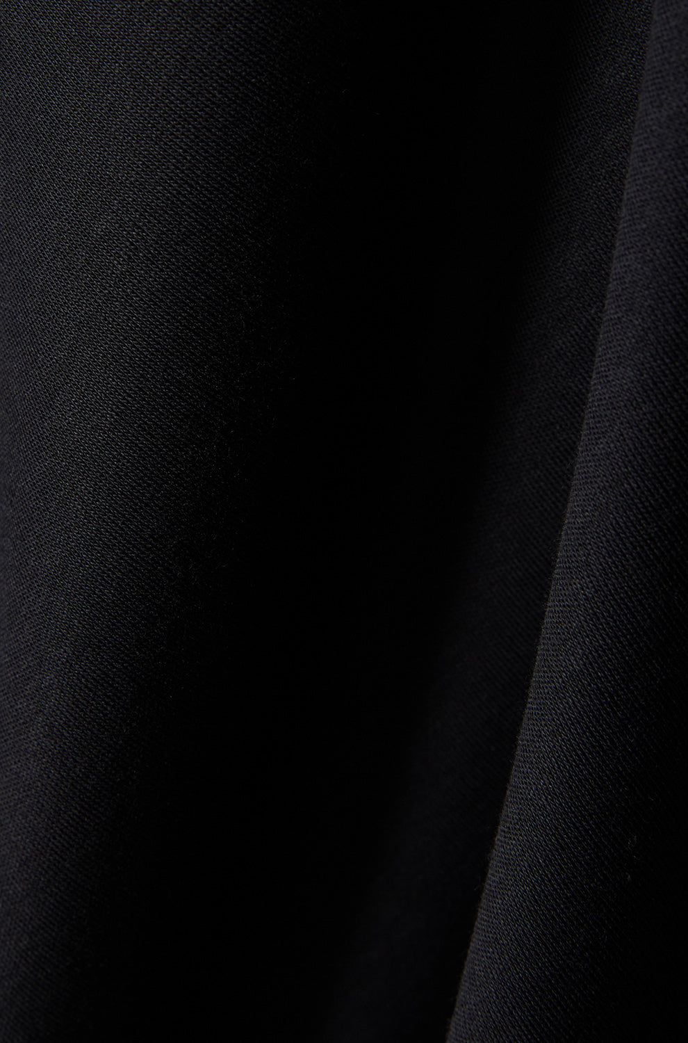 Tissu noir du polo avec une couture foncée et une texture tricot fine pour homme par Psycho Bunny, en gros plan