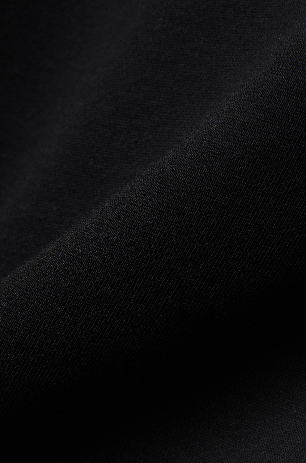 Gros plan du tissu en maille noire du chandail manches longues pour homme par Psycho Bunny