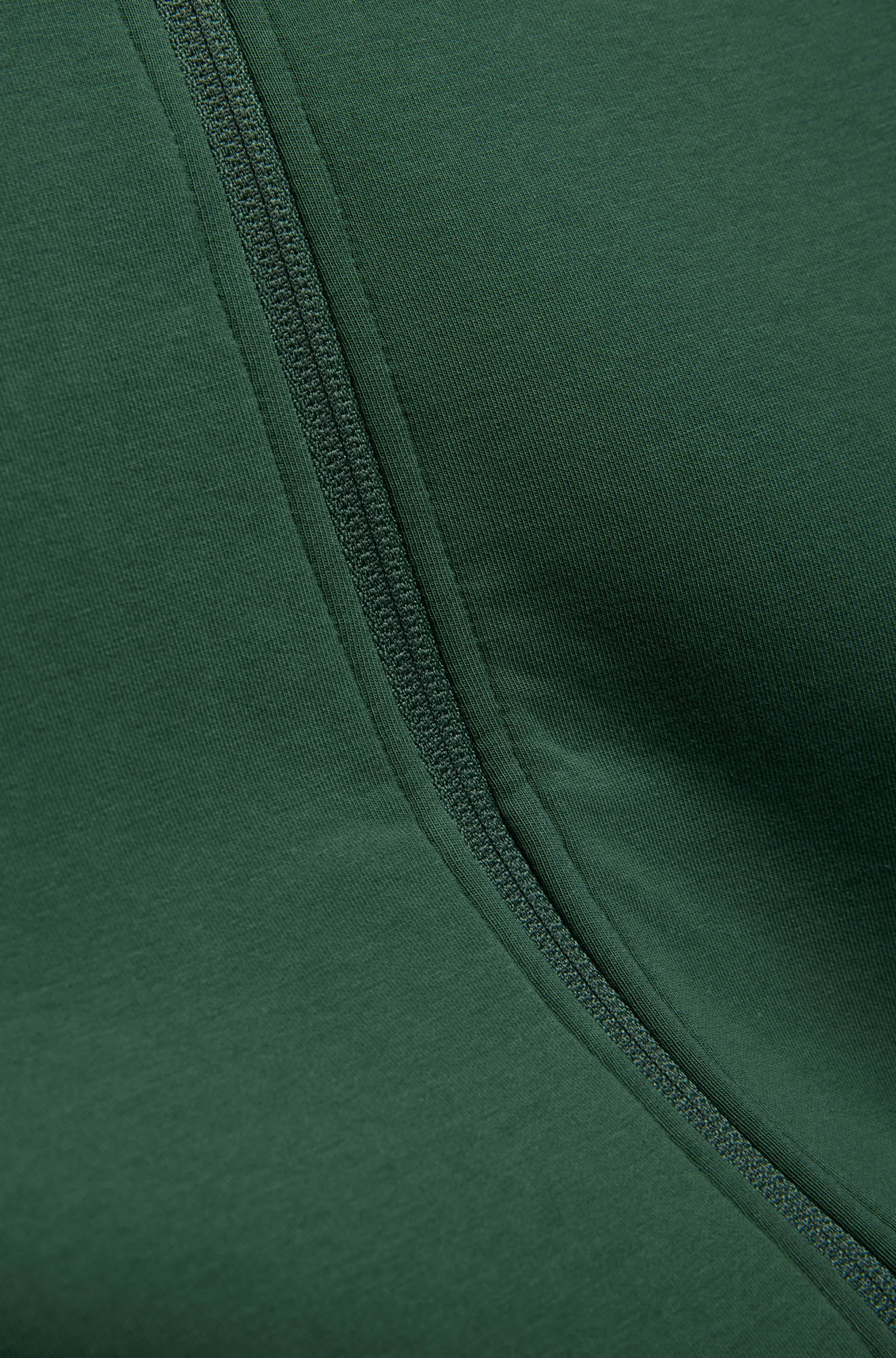 Gros plan du jacket vert foncé et ruban de glissière assorti à l’avant avec tissu tricoté pour homme par Psycho Bunny