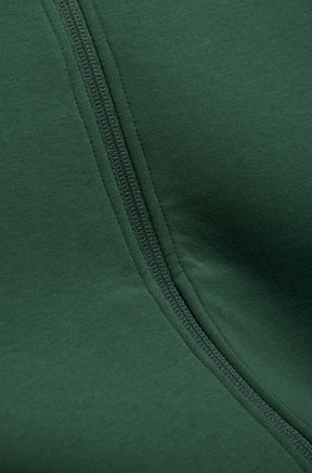 Gros plan du jacket vert foncé et ruban de glissière assorti à l’avant avec tissu tricoté pour homme par Psycho Bunny