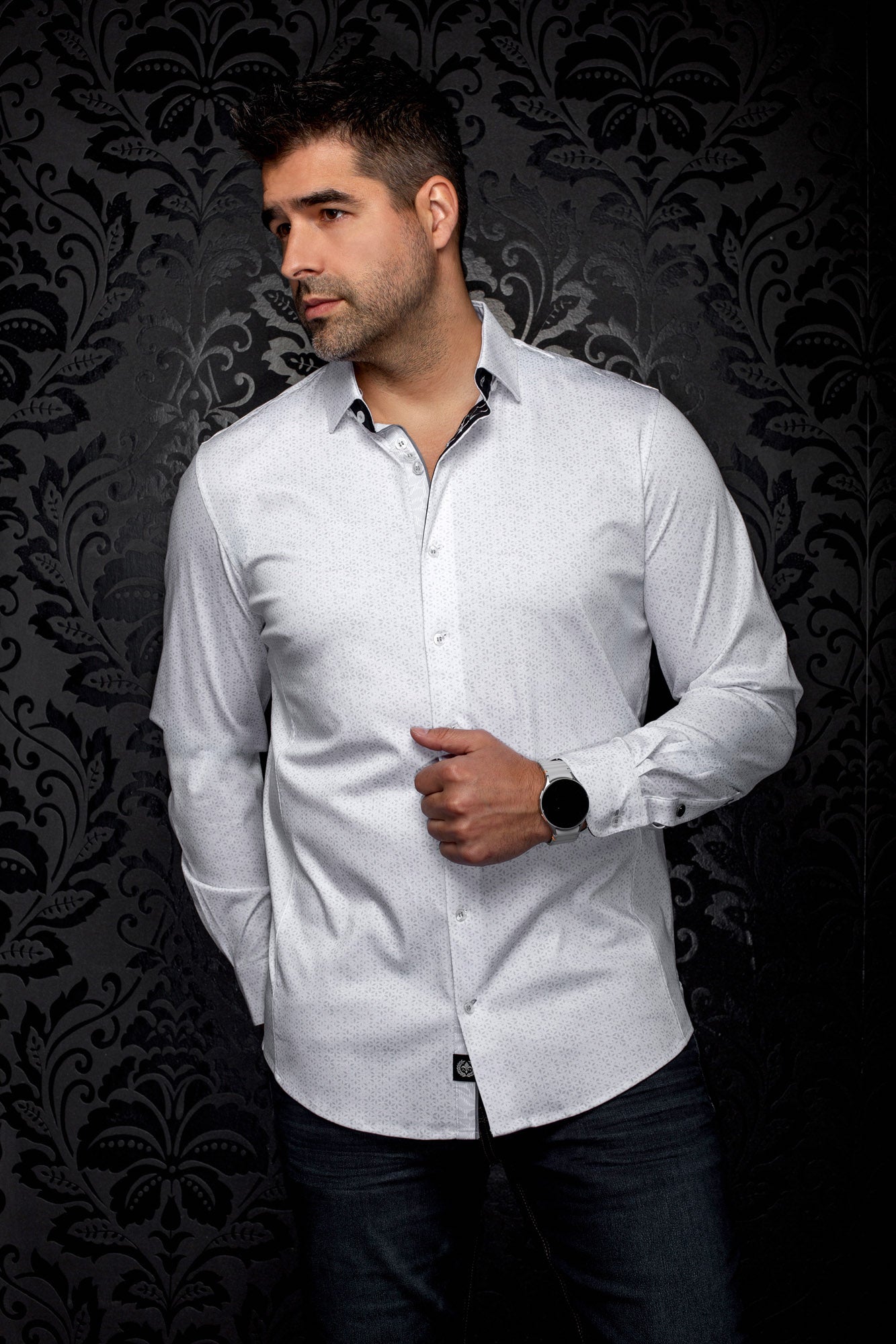 Vue avant sur modèle d’une chemise blanche à manches longues, imprimé gris discret et garniture noire pour homme par Au Noir